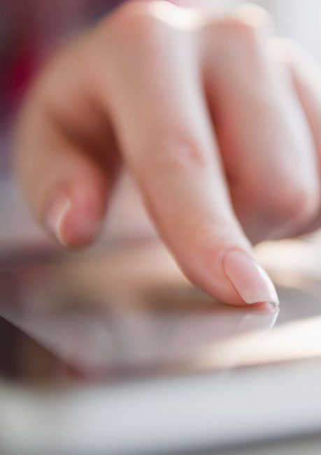 Polished Mobile Nails - female hand with manicured nails using tablet